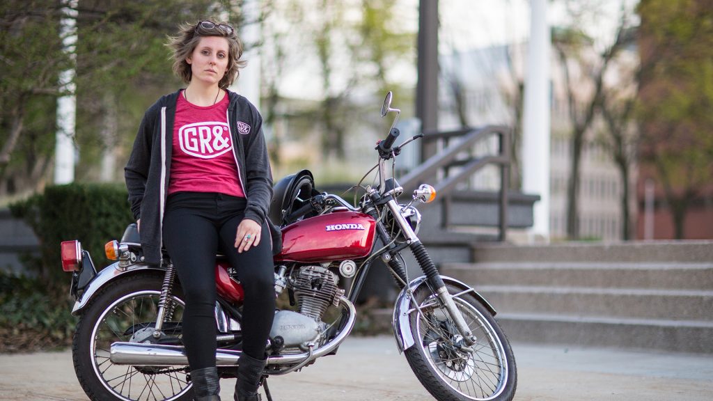 Girl wearing GR& Brand, and leaning up against a motorcycle