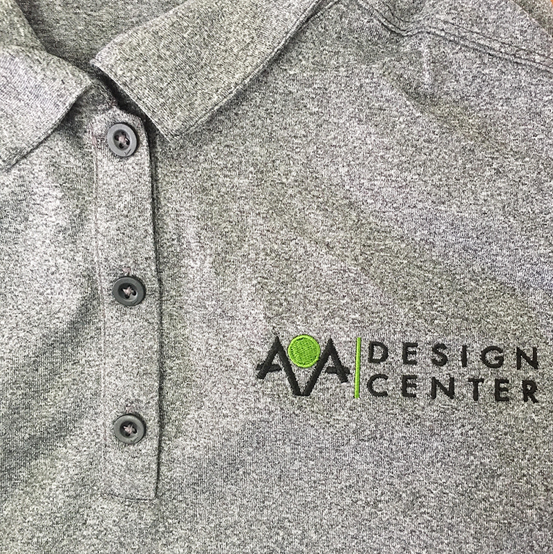 AOA Design Center black and lime green logo embroidered on gray heathered polo. Embroidered at MarkIt Merchandise.