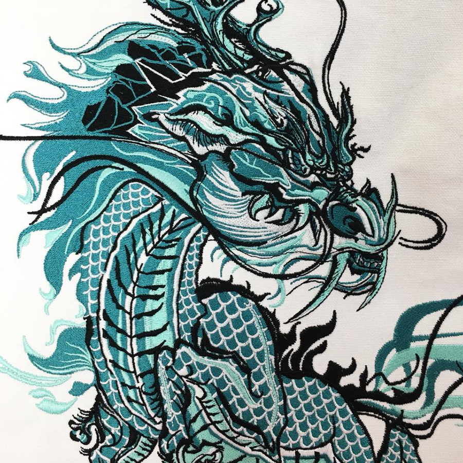 Teal, white and black embroidered dragon. Artwork by Bohan Li. Embroidered at MarkIt Merchandise.