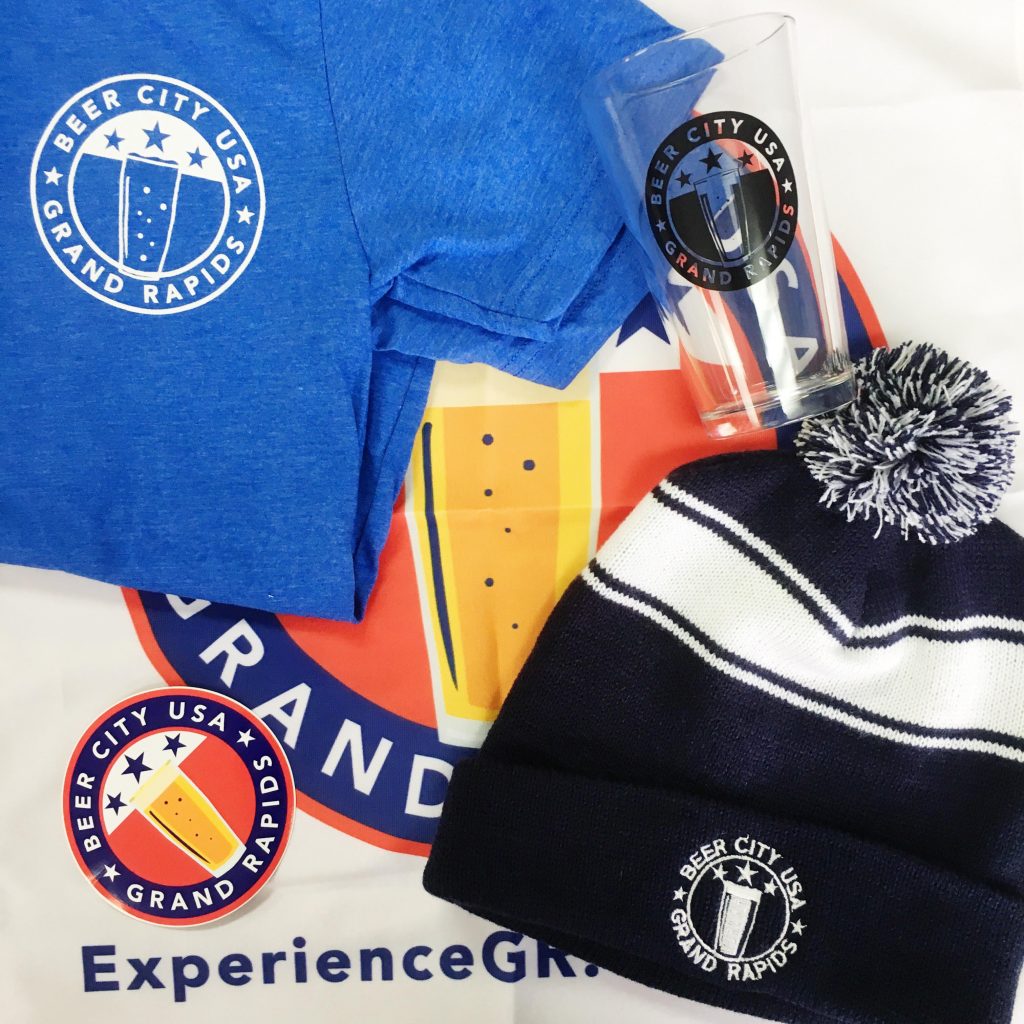 Beer City USA promotional products featuring a hat, glass, t-shirt, banner and sticker.