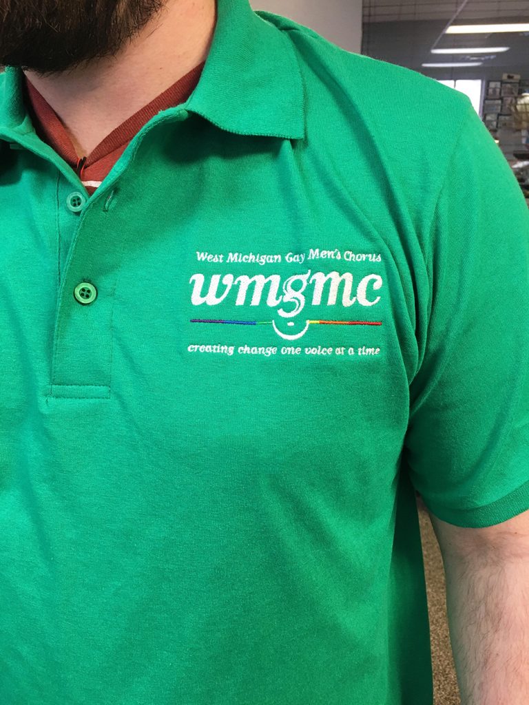 West Michigan Gay Men's Chorus white embroidery on bright green polo. Embroidered at MarkIt Merchandise.